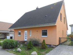 ein orangefarbenes Haus mit schwarzem Dach in der Unterkunft Peenemünde, TOP-Ferienhaus am Seglerhafen in Peenemünde