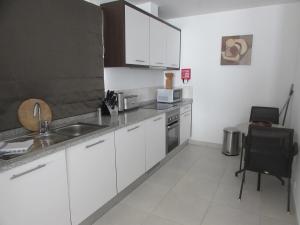a kitchen with white cabinets and a sink at BCV - Private Villas with Pools Dunas Resort 4, 27, and 53 in Santa Maria