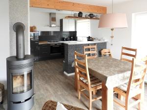 a kitchen with a stove and a table with a fireplace at Peenemünde, TOP-Ferienhaus am Seglerhafen in Peenemünde +6 photos