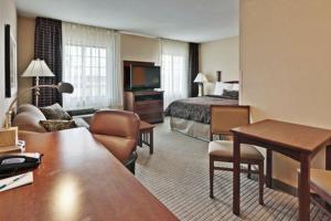 a hotel room with a bed and a living room at Hawthorn Suites by Wyndham Williamsville Buffalo Airport in Williamsville