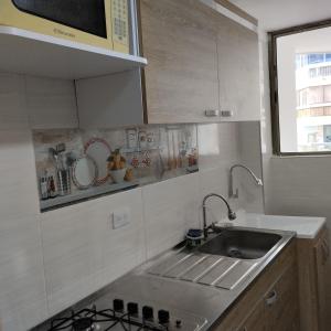 une petite cuisine avec un évier et une cuisinière dans l'établissement CyM Arriendos 904, à Santa Marta