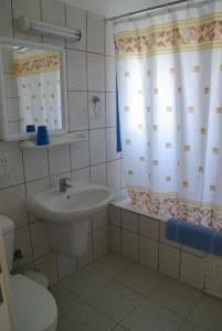 a bathroom with a sink and a shower curtain at Hylatio Tourist Village in Pissouri