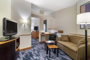 a living room with a couch and a tv at Fairfield Inn & Suites by Marriott Commerce in Commerce