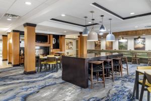 a lobby with a bar and tables and chairs at Fairfield Inn & Suites by Marriott Commerce in Commerce