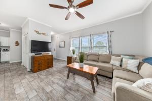 a living room with a couch and a flat screen tv at CozyCoastalRetreat - Steps2Beach - RoomyEscape in Gulf Shores