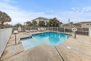 una piscina con sillas y una valla en GulfShores BeachCondo - Pool - FreeParking - SummerTime! - Little Lagoon en Gulf Shores