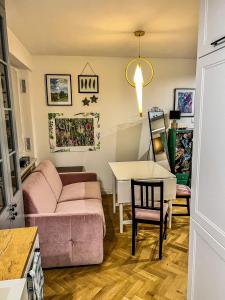 salon z różową kanapą i stołem w obiekcie Apartment by Chopina Street w Koninie