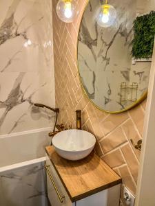 a bathroom with a bowl sink and a mirror at Apartment by Chopina Street in Konin