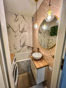 a bathroom with a sink and a washing machine at Apartment by Chopina Street in Konin