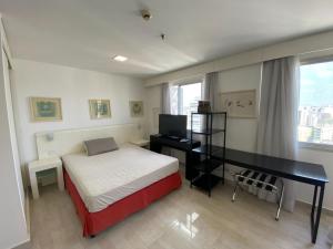 1 dormitorio con 1 cama y escritorio con ordenador en Flat na Vila Olimpia rua Santa Justina, en São Paulo