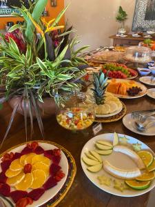 uma mesa com muitos pratos de comida em Hotel Pousada Villa Itália Olímpia em Olímpia