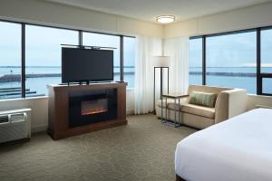 um quarto de hotel com lareira e televisão em Delta Hotels by Marriott Kingston Waterfront em Kingston