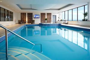 a large swimming pool with blue water and windows at Delta Hotels by Marriott Kingston Waterfront in Kingston