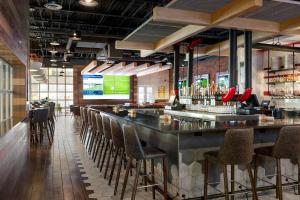a bar in a restaurant with a bunch of stools at Delta Hotels by Marriott - Indianapolis Airport in Indianapolis