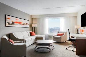 a living room with a white couch and a table at Delta Hotels by Marriott - Indianapolis Airport in Indianapolis