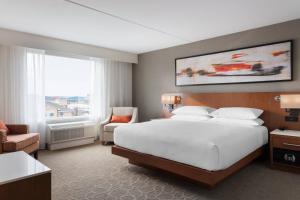 a bedroom with a large white bed and a window at Delta Hotels by Marriott - Indianapolis Airport in Indianapolis