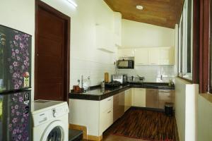 een keuken met een wasmachine en droger. bij VanaJyotsna Forest Home in Maraiyūr