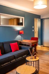 a living room with a couch and a table at Escapade Place 11 - Appartement A2 Dinan centre in Dinan