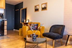 een woonkamer met twee stoelen en een tafel bij Escapade Place 11 N3- Studio Dinan centre in Dinan