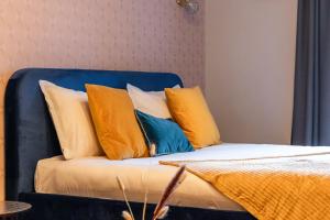 een bed met gele en blauwe kussens erop bij Escapade Place 11 N3- Studio Dinan centre in Dinan