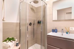 La salle de bains est pourvue d'une douche et d'un lavabo. dans l'établissement Central Superior Suites - Free Parking, à Lugano