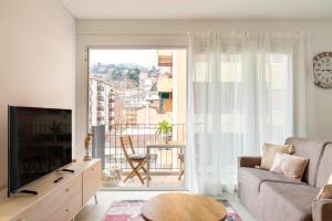 sala de estar con sofá y ventana grande en Central Superior Suites - Free Parking, en Lugano