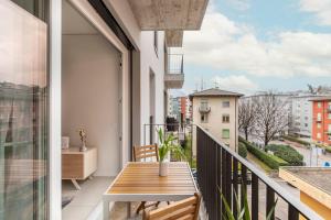balcone con tavolo in legno e vista sulla città di Central Superior Suites - Free Parking a Lugano