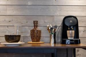 a coffee maker on a table next to a bottle of wine at Escapade Place 11 N5B - Studio Dinan centre in Dinan