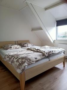 een bed in een witte kamer met een raam bij Vakantiehuis Mastdreef in Breda