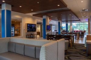 a restaurant with tables and chairs in a building at Holiday Inn Express & Suites - Tuscaloosa East - Cottondale, an IHG Hotel in Cottondale