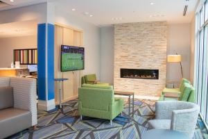 a lobby with chairs and a fireplace at Holiday Inn Express & Suites - Tuscaloosa East - Cottondale, an IHG Hotel in Cottondale