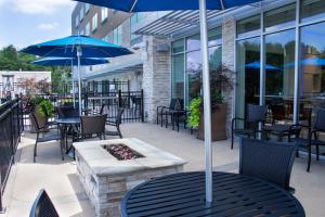 a patio with tables and chairs and umbrellas at Holiday Inn Express & Suites - Tuscaloosa East - Cottondale, an IHG Hotel in Cottondale