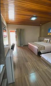 Cette chambre comprend 2 lits et une télévision à écran plat. dans l'établissement Hotel Pousada Villa Itália Olímpia, à Olímpia