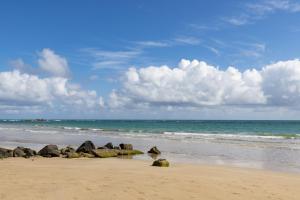 Residence Inn by Marriott San Juan Isla Verde في سان خوان: مجموعة من الصخور على شاطئ مع المحيط