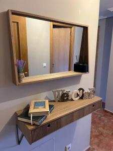 uma mesa de madeira com um espelho e um livro sobre ela em Apartamento Ahola II em Ponferrada