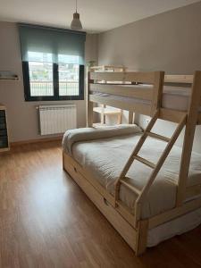 1 dormitorio con 2 literas y suelo de madera en Apartamento Ahola II, en Ponferrada