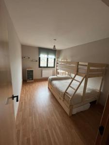 um quarto com 2 beliches e piso em madeira em Apartamento Ahola II em Ponferrada