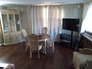 a living room with a table and chairs and a television at Eddystone - Entire Property 