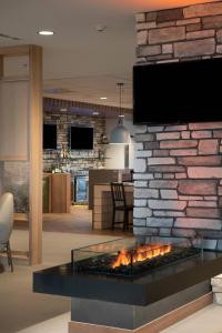 a living room with a fireplace with a tv on a brick wall at Fairfield by Marriott Edmonton International Airport in Edmonton