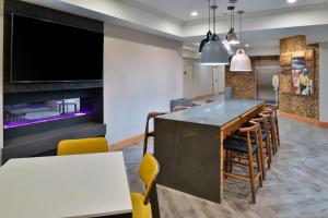 a dining room with a bar and a flat screen tv at Fairfield Inn & Suites Goshen Middletown in Goshen