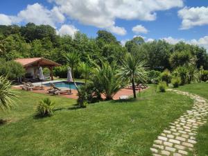 a garden with a swimming pool and a house at Cosy T2, au calme entre mer et montagnes in Saint-Pée-sur-Nivelle