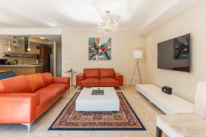 a living room with two orange couches and a table at V&A Waterfront Luxury Apartments from McStay in Cape Town