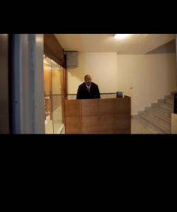 un homme est debout à un bureau dans un bureau dans l'établissement jeeda suites, au Caire
