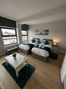 uma sala de estar com 2 camas e uma mesa de centro em King Bed Studio Apartment in Central Northampton em Northampton