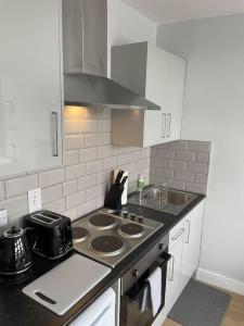 a kitchen with a stove and a counter top at King Bed Studio Apartment in Central Northampton in Northampton
