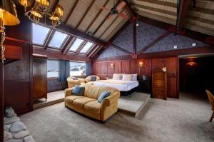 a bedroom with a bed and two couches in a room at Casia Lodge and Ranch in Twisp