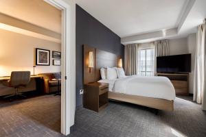 a hotel room with a bed and a desk with a computer at Residence Inn by Marriott Halifax Downtown in Halifax