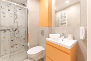 a bathroom with a toilet sink and a shower at Apartamenty Meiera in Kraków +46 photos