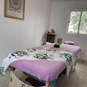 Cama en habitación con manta morada en Terra Aloé, en Torremolinos