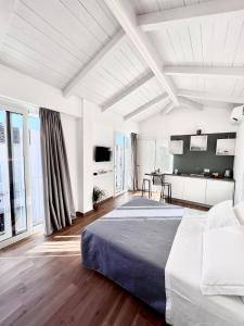 a white bedroom with a bed and a table at Tropea Il Tridente Accommodations in Tropea